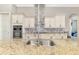 Close-up of kitchen with large granite island, stainless steel appliances, custom cabinets, and a tile backsplash at 10393 Harlingen St, Port Charlotte, FL 33981