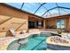 Gorgeous pool with decorative stone accents, surrounded by a brick patio, perfect for poolside relaxation at 10393 Harlingen St, Port Charlotte, FL 33981