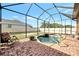 Screened-in pool area featuring a brick patio, lawn, and chairs at 10393 Harlingen St, Port Charlotte, FL 33981