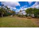 Green backyard with mature landscaping, and an enclosed patio offers a serene outdoor experience at 1169 Presque Isle Dr, Port Charlotte, FL 33952