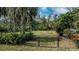Fenced backyard featuring lush greenery, providing a secure and private outdoor space at 1169 Presque Isle Dr, Port Charlotte, FL 33952