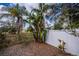 View of a lush backyard with tropical plants and fencing, offering a private outdoor retreat at 1169 Presque Isle Dr, Port Charlotte, FL 33952