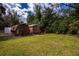 Backyard featuring two storage sheds and a grassy area, surrounded by a chain-link fence at 1169 Presque Isle Dr, Port Charlotte, FL 33952