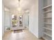 Bright foyer with tiled floor, mirrored walls and decorative light fixture over a double door at 1169 Presque Isle Dr, Port Charlotte, FL 33952