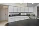 Kitchen with sleek black countertops, white cabinets and stainless-steel sink at 1169 Presque Isle Dr, Port Charlotte, FL 33952