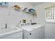 A laundry room featuring a sink, washer, dryer, overhead rack, and window for natural light at 1169 Presque Isle Dr, Port Charlotte, FL 33952