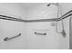 Close up of a walk-in shower with white tile and grab bars at 1169 Presque Isle Dr, Port Charlotte, FL 33952