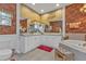 A beautifully decorated bathroom featuring white cabinets, rust colored walls, and a tub next to a cushioned stool at 1350 Old Oak Trl, Port Charlotte, FL 33948