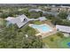 Overhead view of community pool area, featuring a pool, seating, and tennis courts at 1350 Old Oak Trl, Port Charlotte, FL 33948