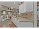 View of the kitchen with white cabinets and a tile backsplash, illuminated by warm lighting at 1350 Old Oak Trl, Port Charlotte, FL 33948
