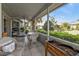 Spacious tiled patio furnished with cozy wicker furniture, surrounded by lush landscaping and views of neighboring homes at 1350 Old Oak Trl, Port Charlotte, FL 33948