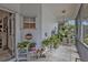 Inviting screened porch adorned with potted plants and charming decor, perfect for relaxing outdoors at 1350 Old Oak Trl, Port Charlotte, FL 33948