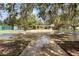 Scenic view of outdoor shuffleboard courts surrounded by mature trees and lush landscaping in a community setting at 1350 Old Oak Trl, Port Charlotte, FL 33948