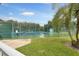 Community tennis courts with green fencing and palm tree landscape, for sports and outdoor fun at 1350 Old Oak Trl, Port Charlotte, FL 33948