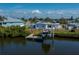Back exterior view of a home with a boat lift, dock, and fenced backyard at 137 Poinsettia Ne Cir, Port Charlotte, FL 33952