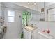 Cozy bathroom with a decorative shower curtain, a vanity with a marble countertop, and a mirrored medicine cabinet at 137 Poinsettia Ne Cir, Port Charlotte, FL 33952