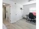 Bright bedroom featuring modern light grey wood-look flooring and a cozy workspace by the window at 137 Poinsettia Ne Cir, Port Charlotte, FL 33952