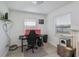 Bright bedroom featuring modern light grey wood-look flooring, a cozy workspace, and natural light at 137 Poinsettia Ne Cir, Port Charlotte, FL 33952