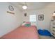 Inviting bedroom with a soft pink comforter, a cute wall decor, a white dresser, and ample lighting at 137 Poinsettia Ne Cir, Port Charlotte, FL 33952