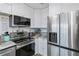 Modern kitchen features stainless steel appliances, granite countertops, and white cabinets at 137 Poinsettia Ne Cir, Port Charlotte, FL 33952