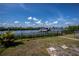 Lush greenery and landscaping by the waterfront, protected by a black fence and leading to the dock at 137 Poinsettia Ne Cir, Port Charlotte, FL 33952