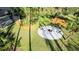 Birds eye view of the circular outdoor fire pit area, with Adirondack chairs on a manicured lawn at 14029 Cain Ave, Port Charlotte, FL 33953