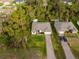 Aerial view of a charming home nestled in a lush, wooded area with a well-maintained lawn and a private driveway at 1470 Atwater Dr, North Port, FL 34288