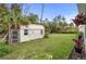 Backyard view showcasing a storage shed with adjacent foliage and plenty of green space at 1470 Atwater Dr, North Port, FL 34288