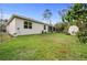 View of the home and yard from the backyard, featuring a white house and storage shed at 1470 Atwater Dr, North Port, FL 34288