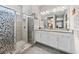 Bathroom features a glass-door shower with leaf design and double vanity with granite counters at 1470 Atwater Dr, North Port, FL 34288