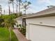 Charming home exterior with a beautiful garden, lush landscaping, and a brick walkway leading to the front entrance at 1470 Atwater Dr, North Port, FL 34288