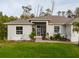 Close-up view of the home's front exterior with a screened entrance, brick path, and lush landscaping at 1470 Atwater Dr, North Port, FL 34288