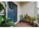 Inviting front porch with blue door, a rocking chair, potted plants, and brick flooring creating a cozy entrance at 1470 Atwater Dr, North Port, FL 34288