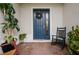 Inviting front porch with brick flooring, rocking chair, potted plants, and a charming blue front door at 1470 Atwater Dr, North Port, FL 34288