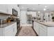 Modern kitchen with white cabinets, granite countertops, stainless steel appliances, and stylish runner at 1470 Atwater Dr, North Port, FL 34288