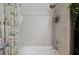 Close-up of tiled shower-tub combo featuring modern fixtures and a floral shower curtain at 1470 Atwater Dr, North Port, FL 34288