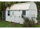 Close-up of the outdoor shed, featuring double doors, a window unit, and ample storage space at 1470 Atwater Dr, North Port, FL 34288