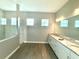 Modern bathroom featuring a double vanity with granite countertops and a large glass-enclosed shower at 15155 Scarlet Oak Ct, Punta Gorda, FL 33955