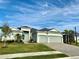 Stunning home with manicured lawn, gray paint, black roof, and an oversized, attached two car garage at 15155 Scarlet Oak Ct, Punta Gorda, FL 33955