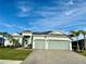 Beautiful one-story home with a large driveway and a well-kept lawn, complemented by palm trees and an attached garage at 15155 Scarlet Oak Ct, Punta Gorda, FL 33955