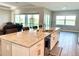 Spacious kitchen featuring an island with seating, stainless steel sink and appliances, and an adjacent living area at 15155 Scarlet Oak Ct, Punta Gorda, FL 33955