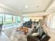Open-concept living room with large sliding glass doors to a lake view, connected to the kitchen at 15155 Scarlet Oak Ct, Punta Gorda, FL 33955