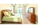 Bright main bedroom with tile floors, view of the lake, and a sliding glass door to the outdoors at 15155 Scarlet Oak Ct, Punta Gorda, FL 33955
