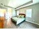 Bright main bedroom with tray ceiling, tile floors, and view to the hallway at 15155 Scarlet Oak Ct, Punta Gorda, FL 33955