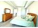 Bright main bedroom with tray ceiling, tile floors, and view to the hallway at 15155 Scarlet Oak Ct, Punta Gorda, FL 33955