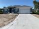 Charming single-story home with a two-car garage and a long concrete driveway at 209 Annapolis Ln, Rotonda West, FL 33947