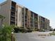 Exterior view of the condo building showing multiple units with screened balconies and parking at 21405 Olean Blvd # 605, Port Charlotte, FL 33952