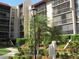 Exterior of the building with multiple screened balconies, beautiful landscaping, and walking paths at 21405 Olean Blvd # 605, Port Charlotte, FL 33952