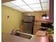 Compact kitchen featuring a stainless steel refrigerator, functional appliances, and efficient cabinet storage solutions at 21405 Olean Blvd # 605, Port Charlotte, FL 33952