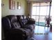 Inviting living room with a plush brown sofa and sliding glass doors to the balcony at 21405 Olean Blvd # 605, Port Charlotte, FL 33952